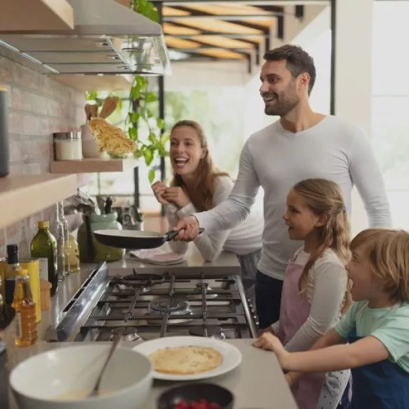 Familie brät Pfannkuchen auf dem Gasherd